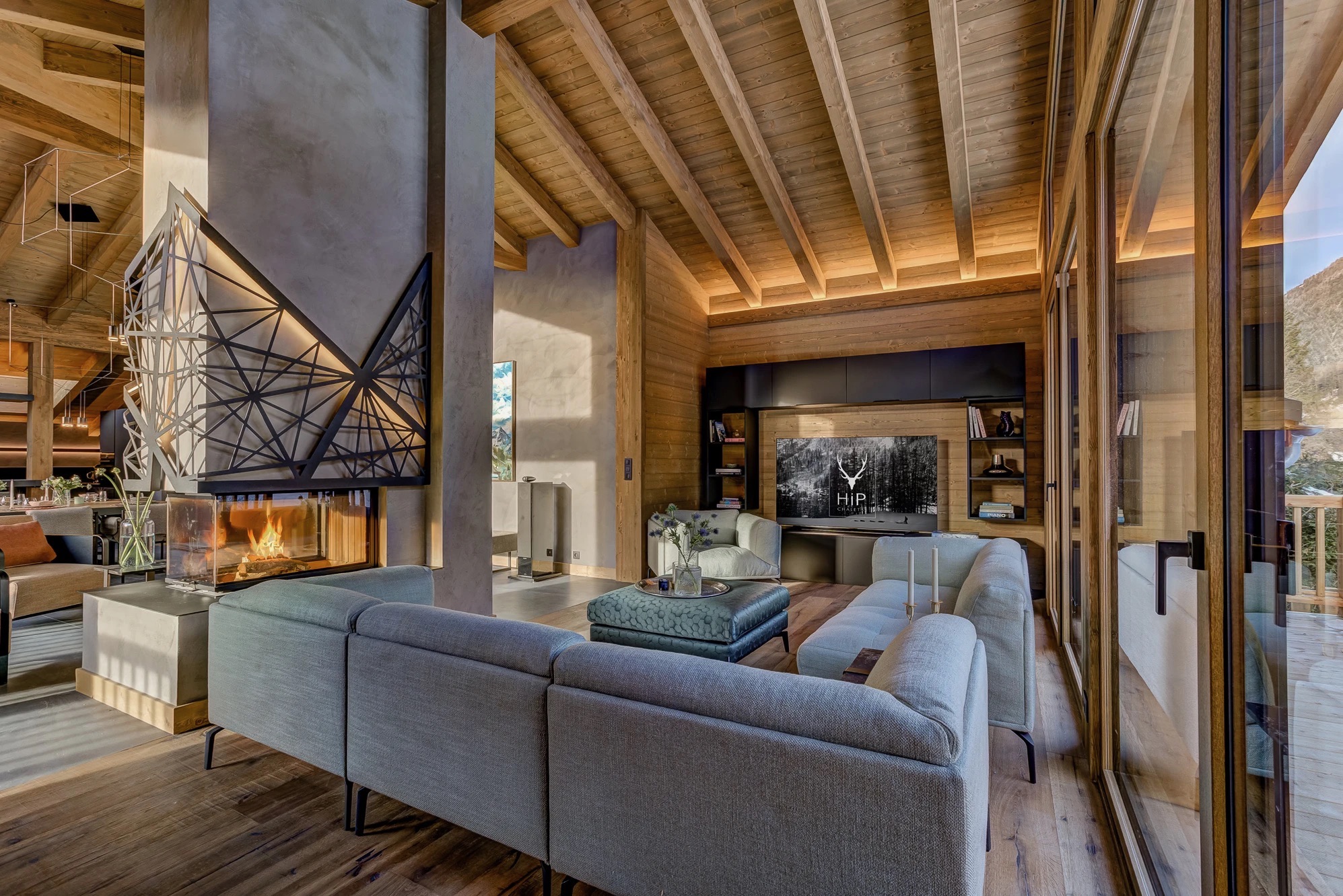Main entertaining room with sculptural sofas and panoramic mountain windows
