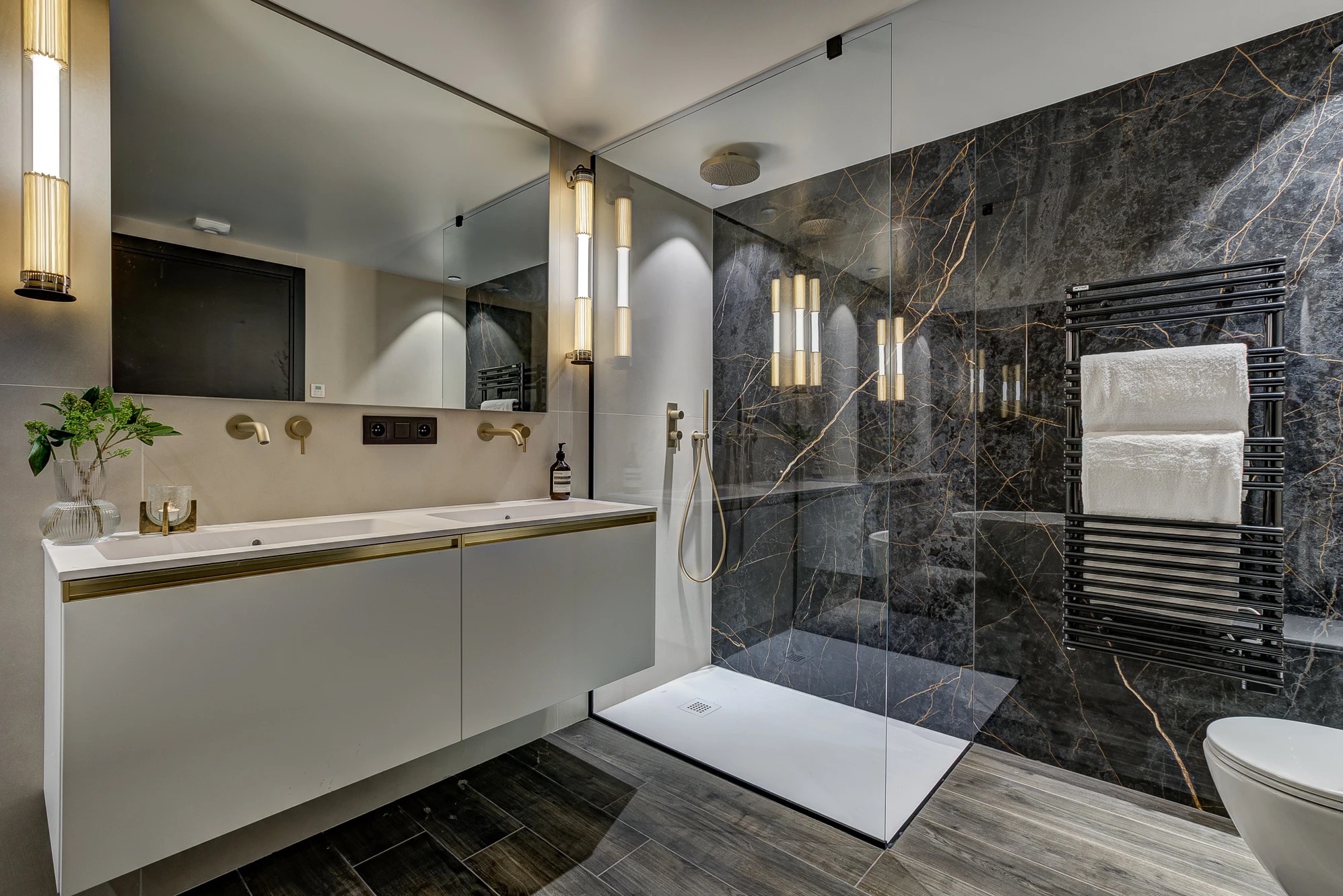 Main bathroom with freestanding tub and warm vertical lighting